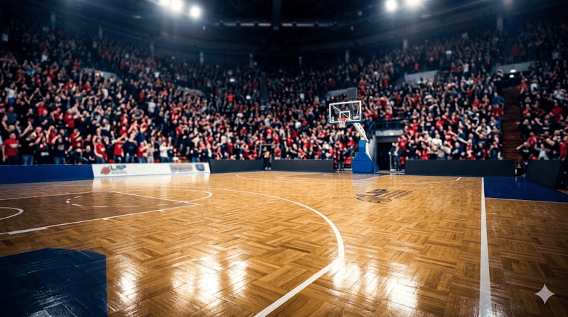 Dettaglio del parquet lucido di un palazzetto del basket illuminato dai riflettori, con gli spalti sfocati sullo sfondo carichi di tifosi in attesa della partita.