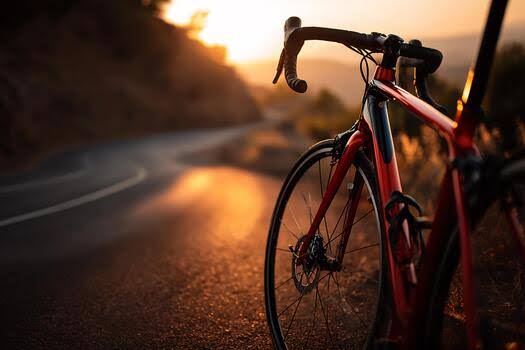 Dettaglio fotografico e cinematografico di una bicicletta da corsa professionale parcheggiata su una strada asfaltata con luce calda del tramonto, simbolo dell'inizio delle tappe del Giro d'Italia Women.