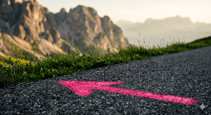 Dettaglio in primo piano dell'asfalto stradale con una striscia rosa dipinta a terra su un passo alpino, in attesa del Giro d'Italia.