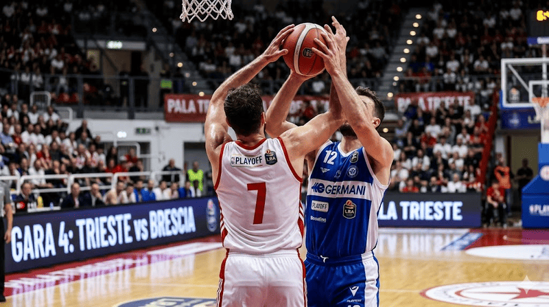 Giocatore in canotta bianca tenta di stoppare il suo avversario durante una partita di basket.